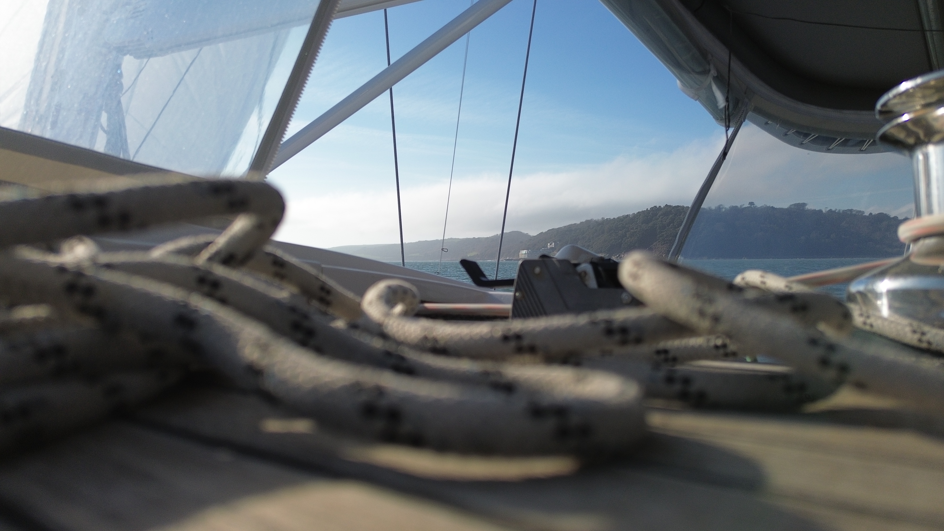 Sailing rope coiled around a chrome cleat on deck